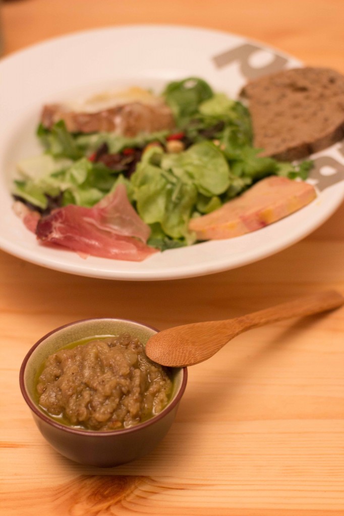 Caviar d'aubergine servi avec une grande salade verte, des fruits secs, du jambon de pays et autres antipastis.
